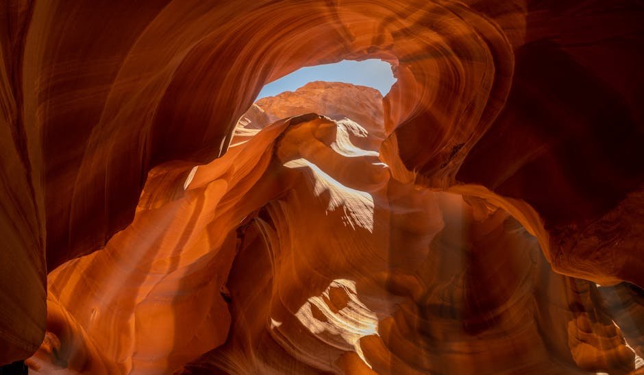 Sunlight pours into the iconic Antelope Canyon, showcasing its stunning sandstone formations.