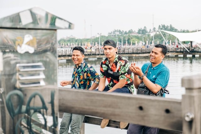 man in blue crew neck t-shirt sitting on brown wooden bench