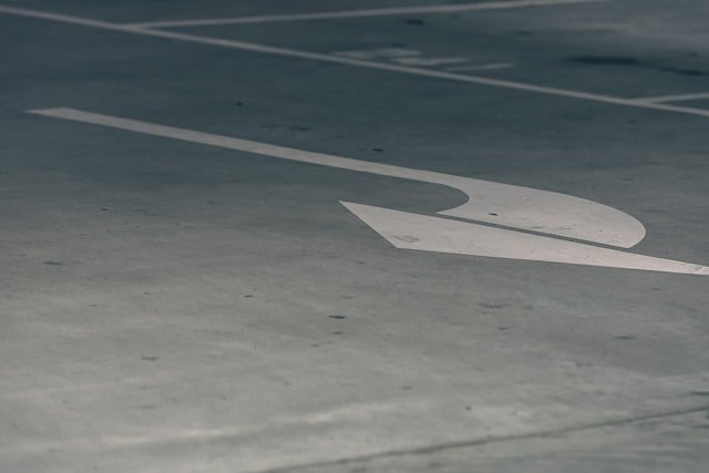 a parking lot with a white arrow painted on it