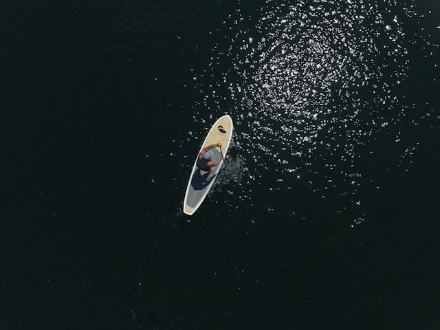 white and black surfboard on body of water