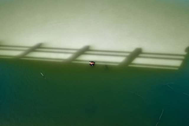 Shadows cast across a green and yellow surface.