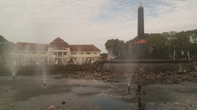 A fountain and monument are featured.