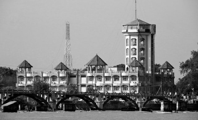 grayscale photo of building near body of water