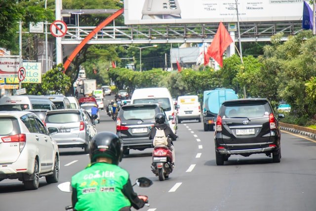a man riding a motorcycle down a street filled with traffic